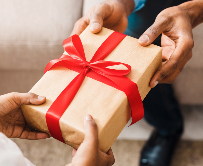 Person Accepting wrapped gift in a red bow tie